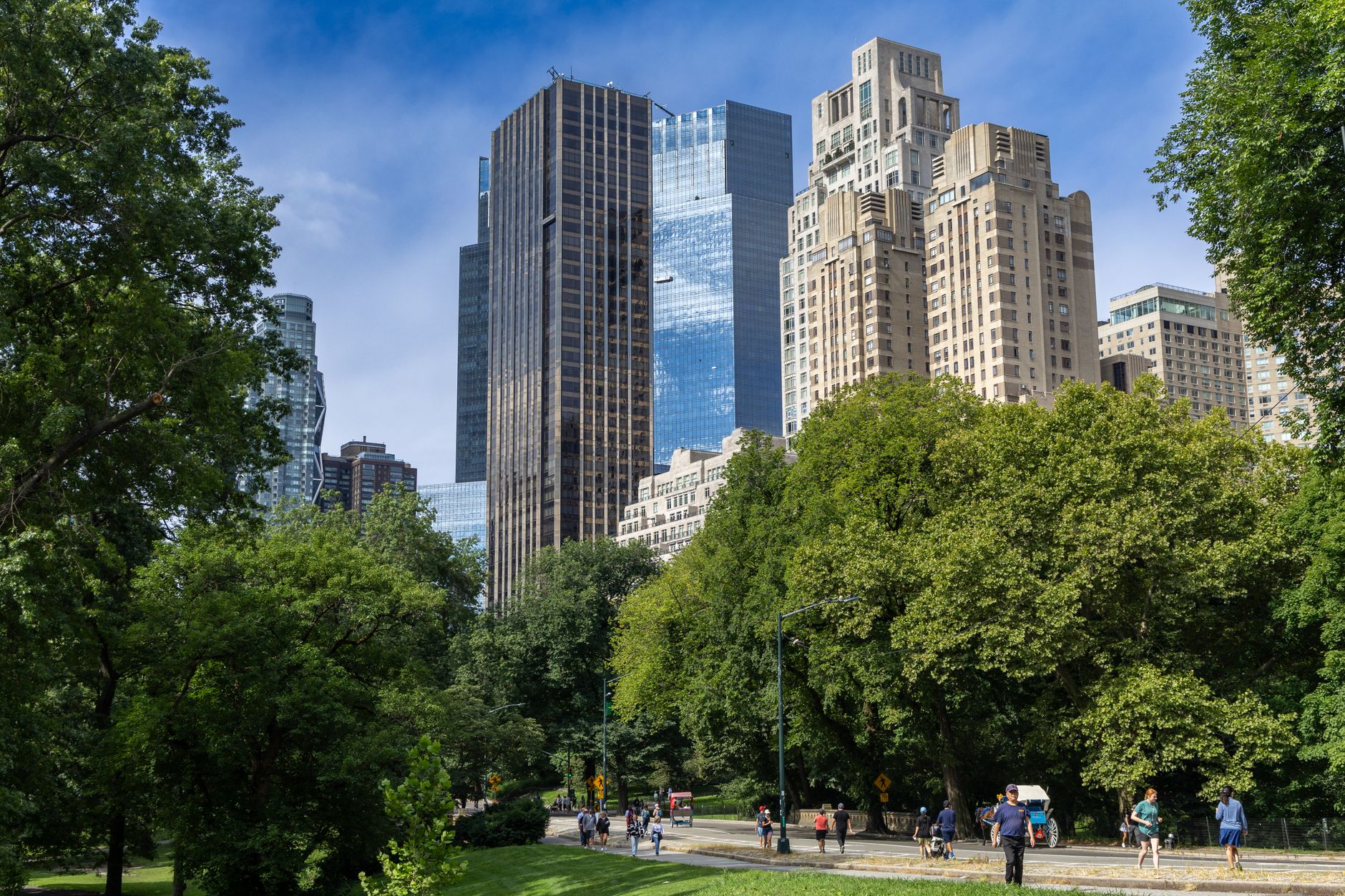New York City skyline view with towering skyscrapers and lush Central Park greenery.